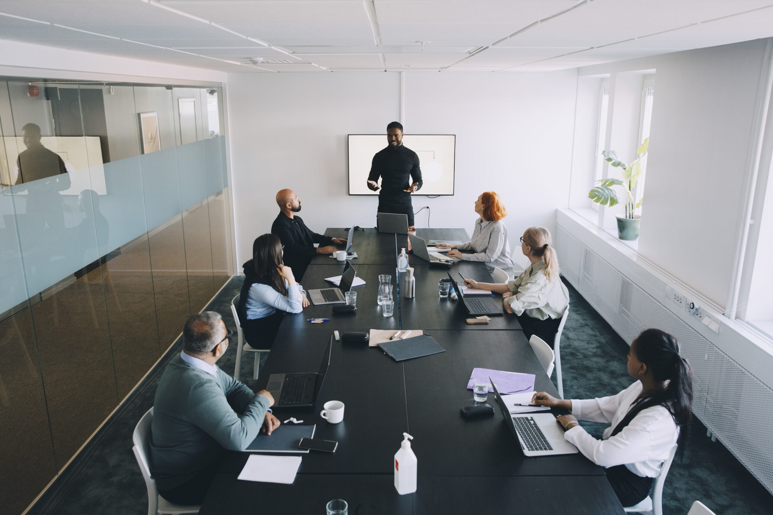 High angle view of businessman giving presentation colleagues in board room at office